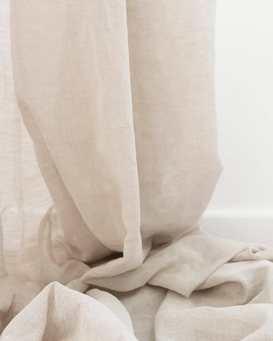 Warm linen drape at the clinic entrance, filtering the daylight