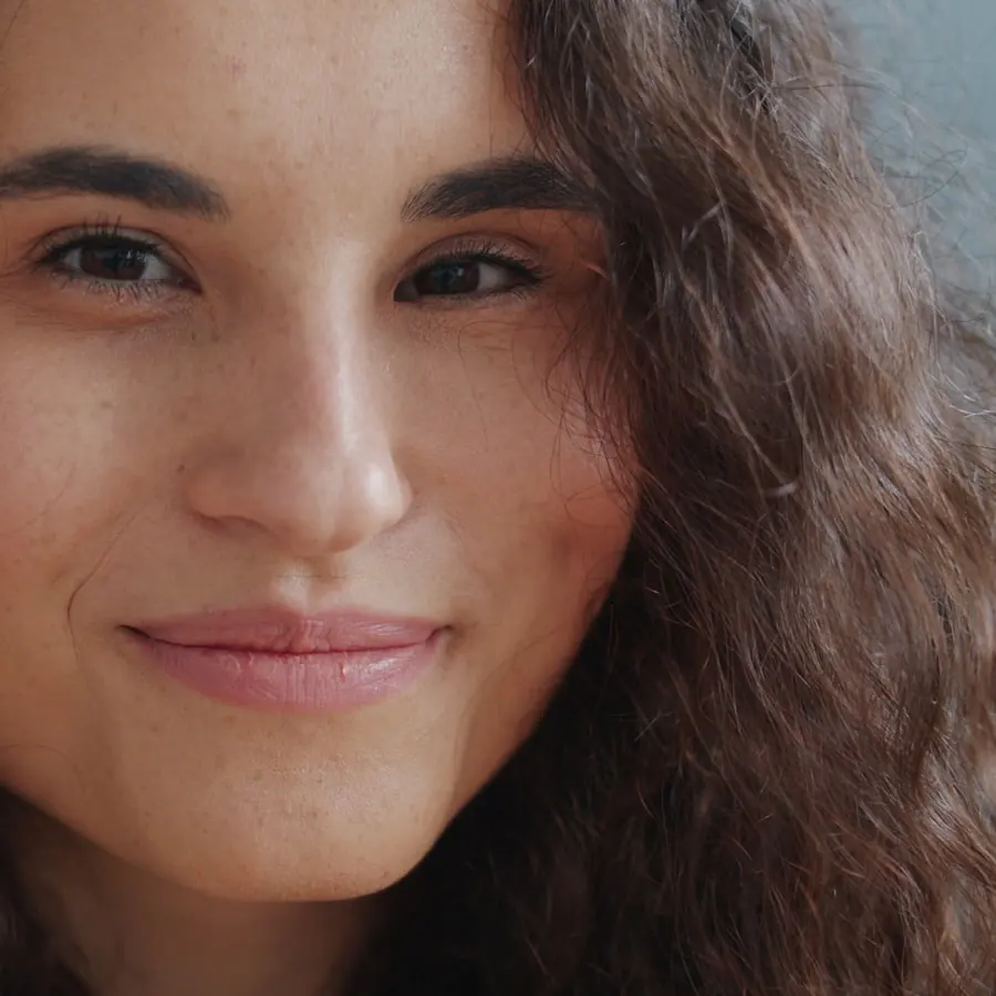 Woman smiling gently in warm natural light, skin looking calm and healthy